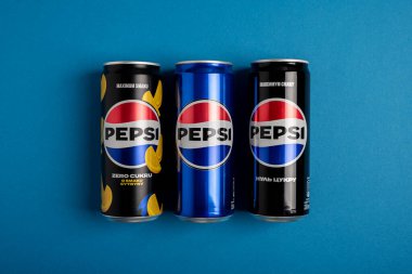 Lviv, Ukrayna - 25 Mayıs 2025: Pepsi Zero Sugar Soda, Klasik Soda ve Sıfır Şeker Citrus Soda Konserveleri mavi arka planda. Üst görünüm