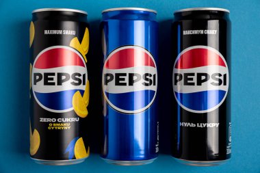 Lviv, Ukrayna - 25 Mayıs 2025: Pepsi Zero Sugar Soda, Klasik Soda ve Sıfır Şeker Citrus Soda Konserveleri mavi arka planda. Üst görünüm