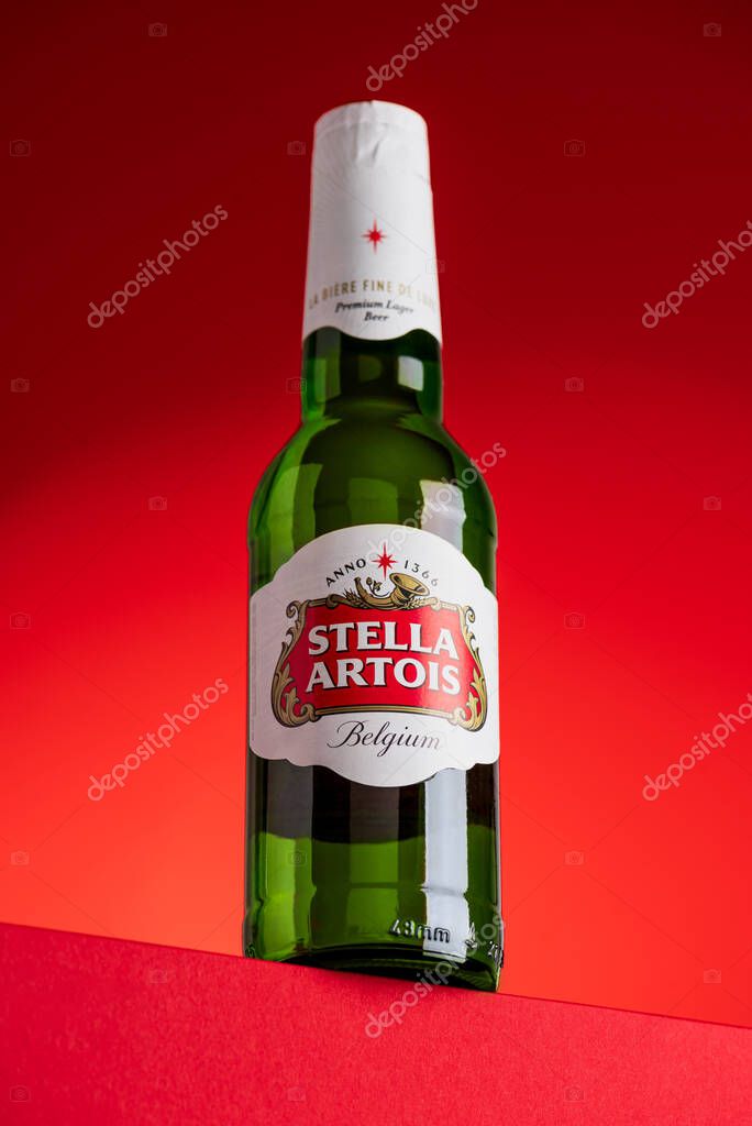 Lviv, Ukraine - May 25, 2025: Stella Artois lager beer glass bottle on red background