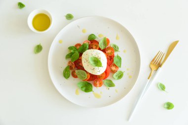 Mozarella, domates ve fesleğenli taze Caprese salatası, ekmekle servis edilir..