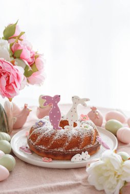 Beyaz tahta masa üzerinde tavşan şeklinde zencefilli kurabiyelerle süslenmiş geleneksel paskalya pastaları.