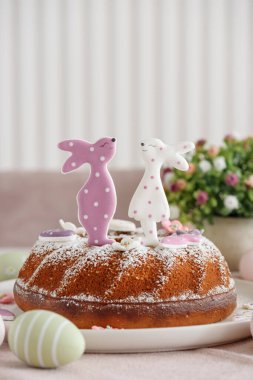 Beyaz tahta masa üzerinde tavşan şeklinde zencefilli kurabiyelerle süslenmiş geleneksel paskalya pastaları.