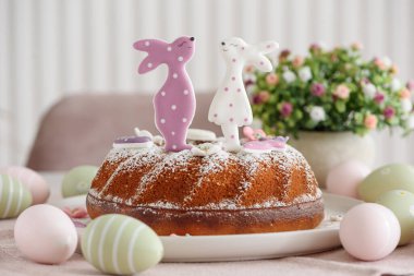 Beyaz tahta masa üzerinde tavşan şeklinde zencefilli kurabiyelerle süslenmiş geleneksel paskalya pastaları.