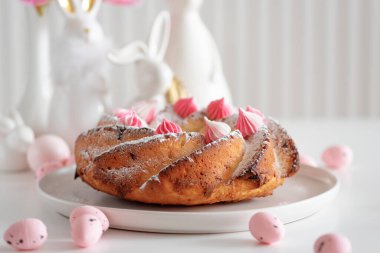 Geleneksel Paskalya pastaları, beyaz ahşap masa üzerinde süslemeli şekerler.