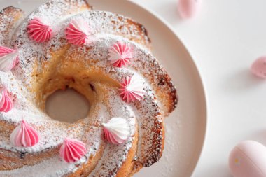 Geleneksel Paskalya pastaları, beyaz ahşap masa üzerinde süslemeli şekerler.