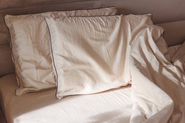 Yumuşak yastıklar ve buruşuk çarşaflar rahat bir yatakta.