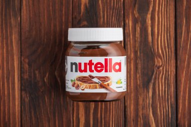 Lviv, Ukrayna - 19 Haziran 2025: Ahşap arka planda fındıklı fındık kavanozu. Üst görünüm