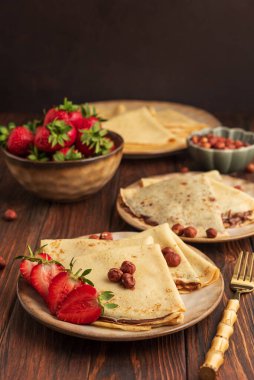 Fındıklı krep, çilek ve fındıklı ahşap masa..