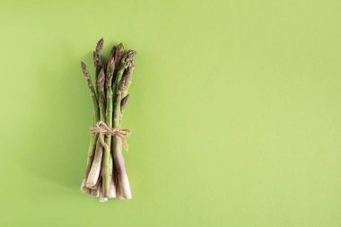 Canlı yeşil arka planda taze kuşkonmaz. Üst görünüm