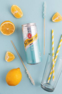 Lviv, Ukrayna - 6 Nisan 2025: Demir kutu Schweppes Bitter Lemon ve kokteyl malzemeleri. Üst görünüm