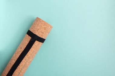 Mavi arka planda yuvarlanmış yoga minderi..