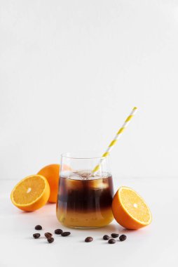 Portakal ve espresso ile kaplı katmanlı Bumble Kahve, beyaz masada bir bardakta servis edilir.