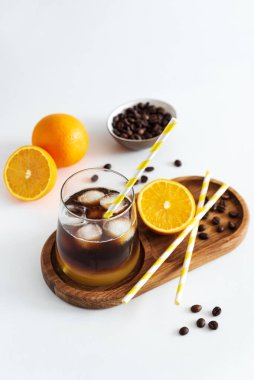 Portakal ve espresso ile kaplı katmanlı Bumble Kahve, beyaz masada bir bardakta servis edilir.