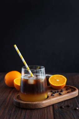 Portakal ve espresso ile kaplı Katmanlı Bumble Kahve, koyu ahşap arka planda bir bardakta servis edilir.