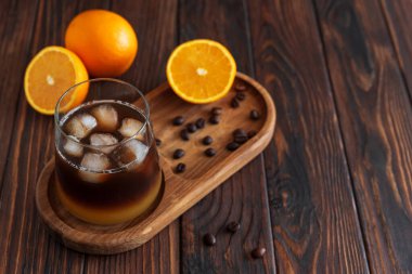 Portakal ve espresso ile kaplı Katmanlı Bumble Kahve, koyu ahşap arka planda bir bardakta servis edilir.