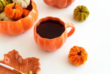 Balkabağı süslemeli sonbahar çay seti ve beyaz bir masada pasta..