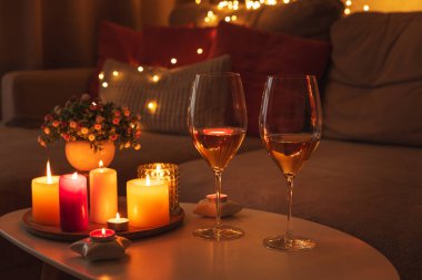 Mumlar, şarap kadehleri ve sıcak ışıklandırmayla sıcak bir akşam sahnesi..