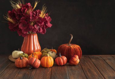 Ahşap bir yüzey üzerinde dekoratif mini balkabaklarının sonbahar kompozisyonu.