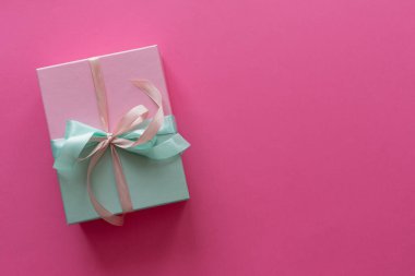 Pembe arka planda Noel hediyesi.