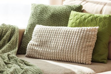 Saf bej koltukta desenli yastıklar ve battaniye