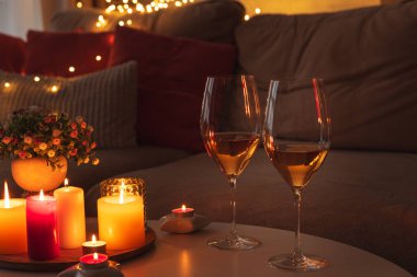 Mumlar, şarap kadehleri ve sıcak ışıklandırmayla sıcak bir akşam sahnesi..