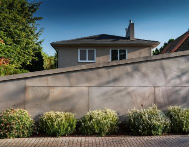 Önünde yapraklar ve çiçeklerle duvarları olan arka planda güzel bir ön ev.