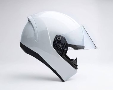 Beyaz motosiklet kaskı beyaz bir zeminde yüzüyor.