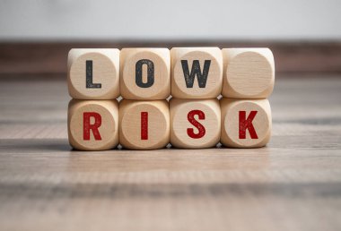 Yüksek riskli küp, zar veya bloklar ve ahşap arka planda düşük risk