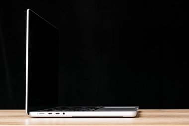 Masa arkasında siyah ekranı olan modern dizüstü bilgisayar