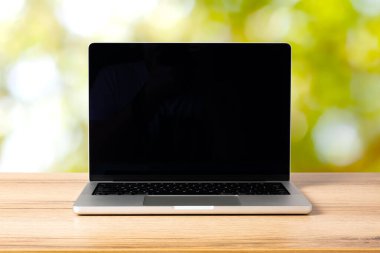 Masa arkasında siyah ekranı olan modern dizüstü bilgisayar