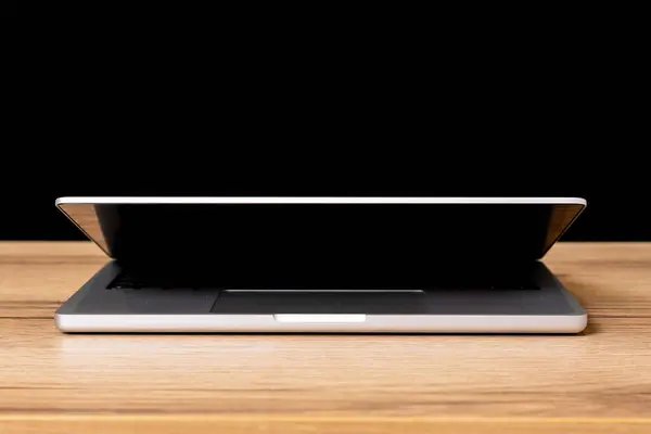 Masa arkasında siyah ekranı olan modern dizüstü bilgisayar