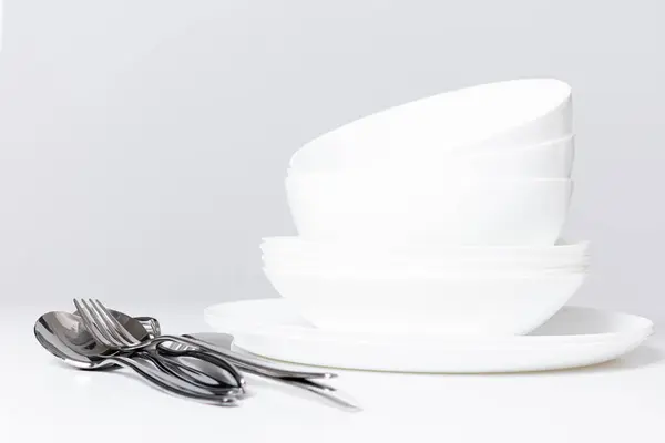 Beyaz arkaplanda boş beyaz tabaklar