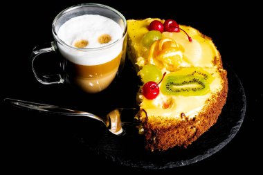 Siyah arkaplanda servis edilen, cam bardakta latte..