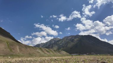 Timelapse Sunny Day in the Mountains - Bulutlar Gökyüzünde İlerliyor, Yemyeşil Çimen, Ağaçlar, Soluk Kesen Köy Manzarası Geleneksel Evler, Beton Yolu ve Sinema Beyaz Bulutları 4k