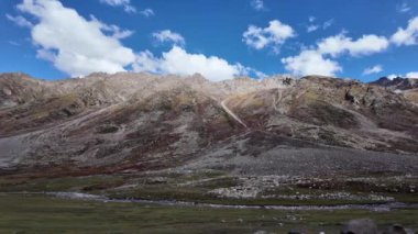 4K Nehir Manzarası Önden Arkaya Hareketli Kamera Kayaların Üzerinden Geçen Temiz Su Çekimi, Görkemli Güneş Işığı Kayalık Dağlar ve Güzel Hava Kabarık Bulutlu