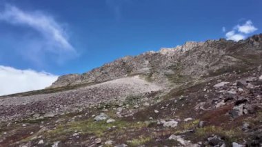 4K Dağ Majestelerinin Yavaş Hareketli Dağ Manzarası Soluk Kesen Dağ Manzarası, Sarkık Yeşil Çayırlar, Yüksek Tepeler, Yapı Hareketi Bulutları, Parlak Mavi Gökyüzü Dönen Yol