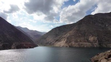 Sinematik Hava Görüntüsü Huzurlu Göl Görkemli Dağlar ve Güneş Işığı, dramatik bulutlar, mavi gökyüzü ve beyaz kabarık bulutlar, Dağlar Manzarası, Kara Bulutlar, Yapı Hareketli Bulutlar