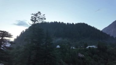 Akşam Arabası Sahnesi Yol Kenarı Nehri, Ağaçlar, Görkemli Dağlar ve Dramatik Gökyüzü Altında Pişirme Dumanı Olan Sıcak Evler