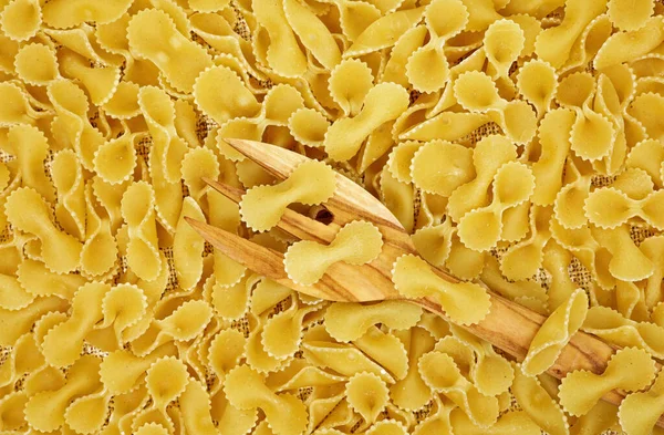 close-up of uncooked pasta background with a wooden fork