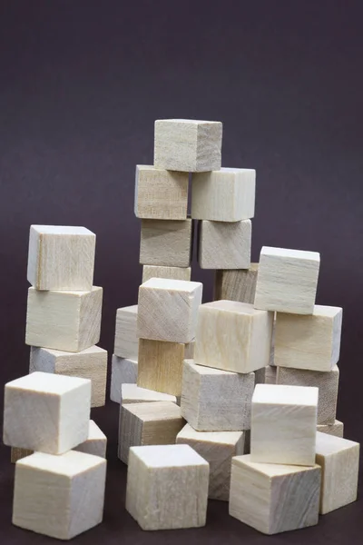 stacked small wooden cube blocks on a dark background