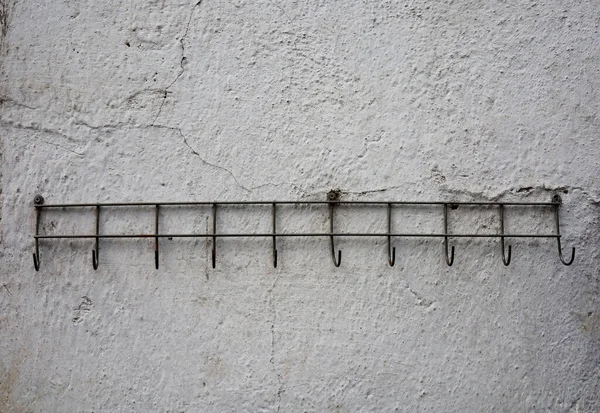 old metal clothes hanger hanging on concrete wall