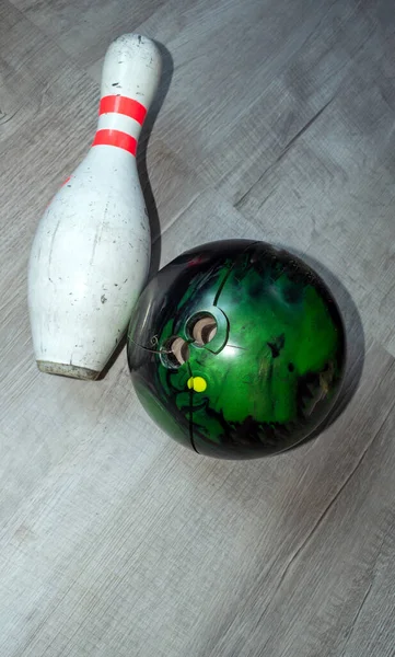 着用し 壊れた緑のボウリングボールのトップダウンビューと灰色の専用フロアにピンを使用 — ストック写真