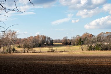 Missouri 'de sonbahar günü mavi gökyüzüyle yeni sürülmüş bir tarlanın bulunduğu güzel bir kır manzarası. Bokeh.