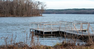 Kahverengi çorak ağaçlar ve boş rıhtım platformu bu huzurlu Oklahoma gölünde henüz balıkçılık havasının olmadığını gösteriyor..