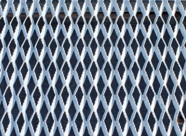 Metal bir ızgara zemin eğri üçgenli güzel bir arkaplan ya da doku deseni oluşturur.