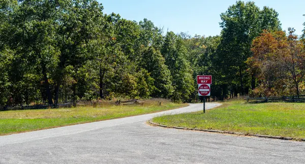 stock image The country road is vacant but the sign gives instructions for motorists warming them not to enter. A wooden rail fence and a tree lined paved road makes a peaceful country scene in Arkansas.