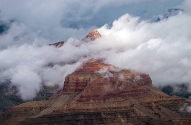 Büyük kanyon üzerindeki yoğun sis bulutları, aşağıdaki vadiyi kaplıyor. Güzel sahne merak ve gizemin nefes kesici bir görüntüsüdür..