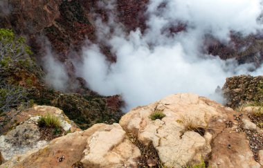 Arizona 'daki güzel Grand Canyon Ulusal Parkı' ndaki kaya çıkıntısının altındaki beyaz sis bulutlarının yakın görüntüsü..