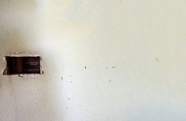 Boş yıpranmış bir duvar ve bir zamanlar elektrik prizi kurulmuş. Bu alan, eski yapıda yeni kurulum veya bakım çalışmaları sırasında yama için açık kalır.