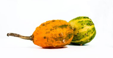 İki renkli kabak, beyaz arkaplana karşı sergileniyor. Hafif gölgeler, izleyicilere dram ve görsel ilgi katar..